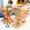 A wooden pick-up sticks board game with colorful sticks and balls is being played by a family.