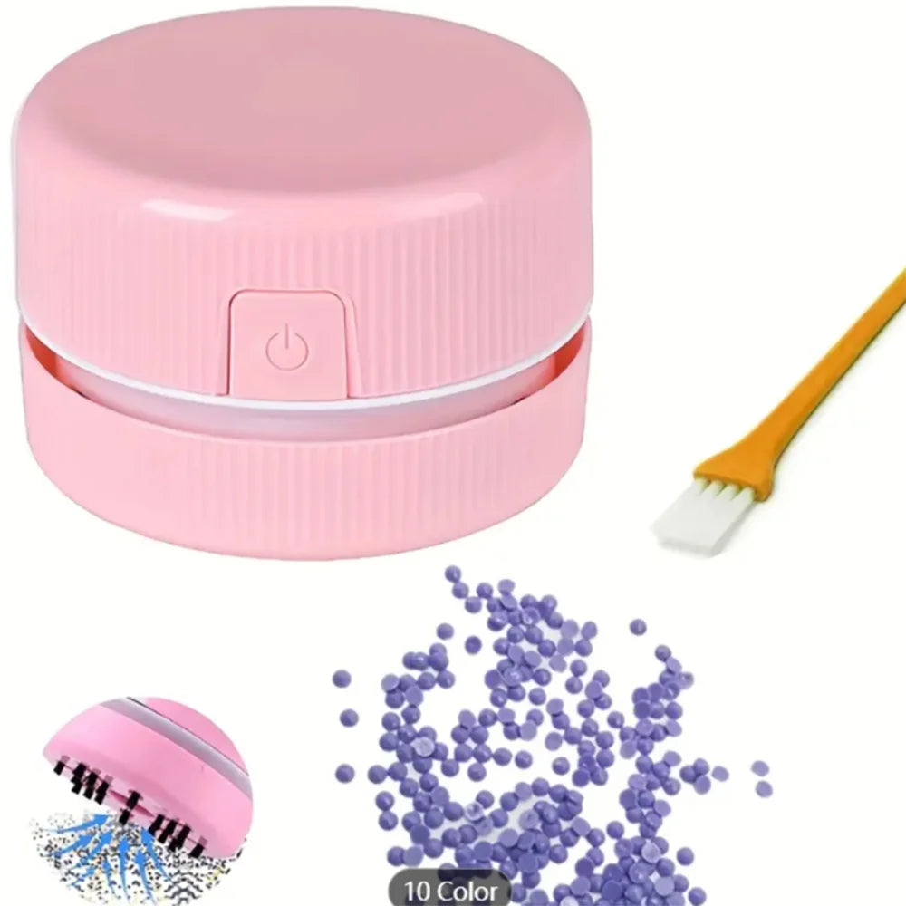 Rosa Mini-Schreibtischstaubsauger mit Bürste und lila Reinigungsbällen