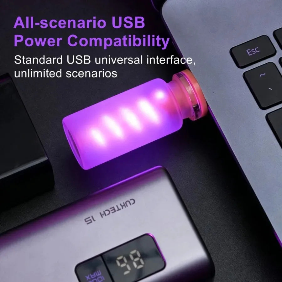 A purple USB LED night light in a frosted glass bottle is shown next to a laptop keyboard.
