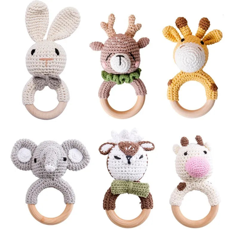 A collection of crochet bunny and elephant rattles with natural wood teether rings.