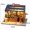 A wooden miniature Japanese sakura tea house kit featuring an illuminated display cabinet and various tea items.