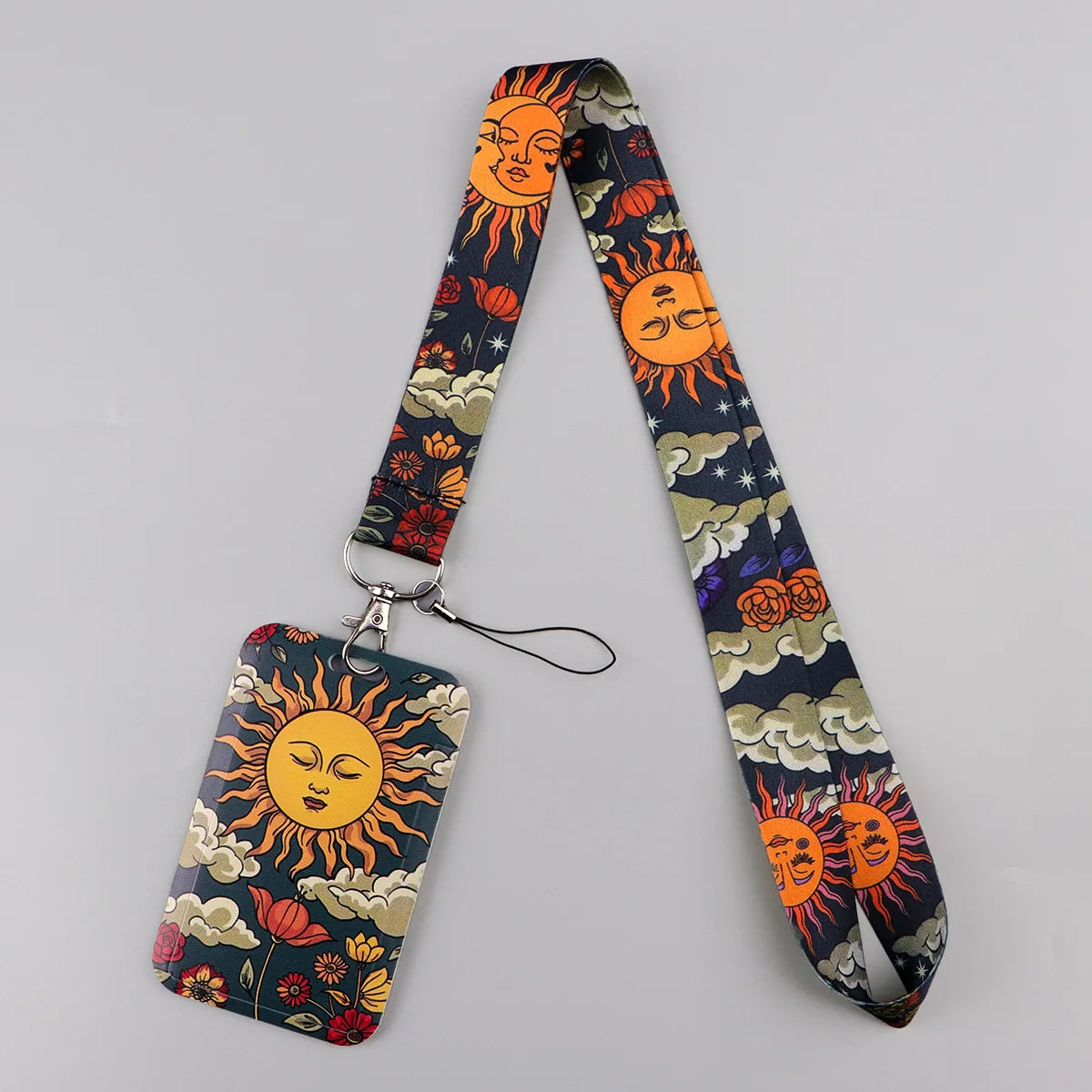 A lanyard featuring a patterned fabric with sun and moon designs attached to an ID badge holder.