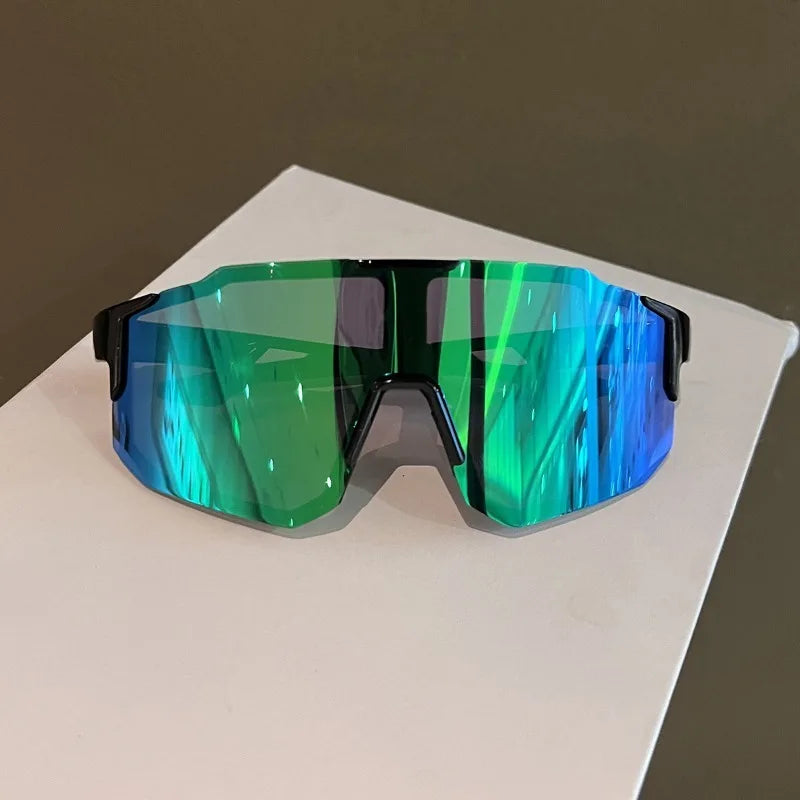 A pair of green-tinted cycling sunglasses resting on a white surface.