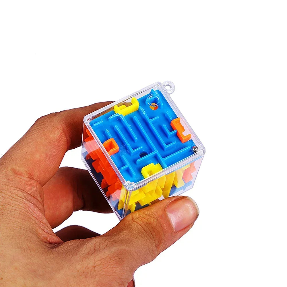 A hand holds a transparent cube puzzle with blue and orange maze pieces inside.