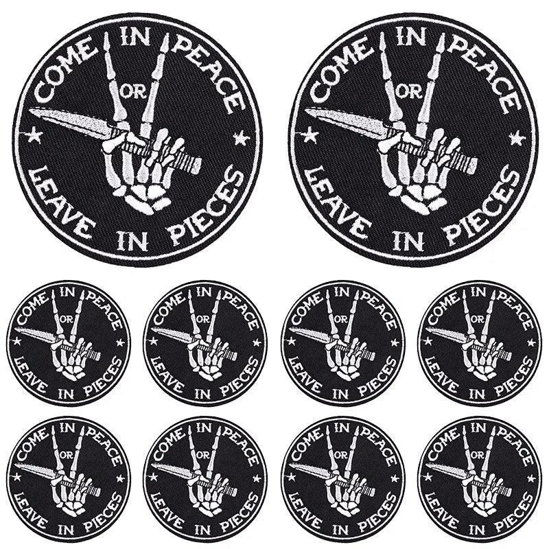 Ten black embroidered iron-on patches featuring a hand making a peace sign with a sword, surrounded by the text Come in Peace