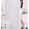 A white striped microfiber towel hanging on a rack next to a woman in a light top.
