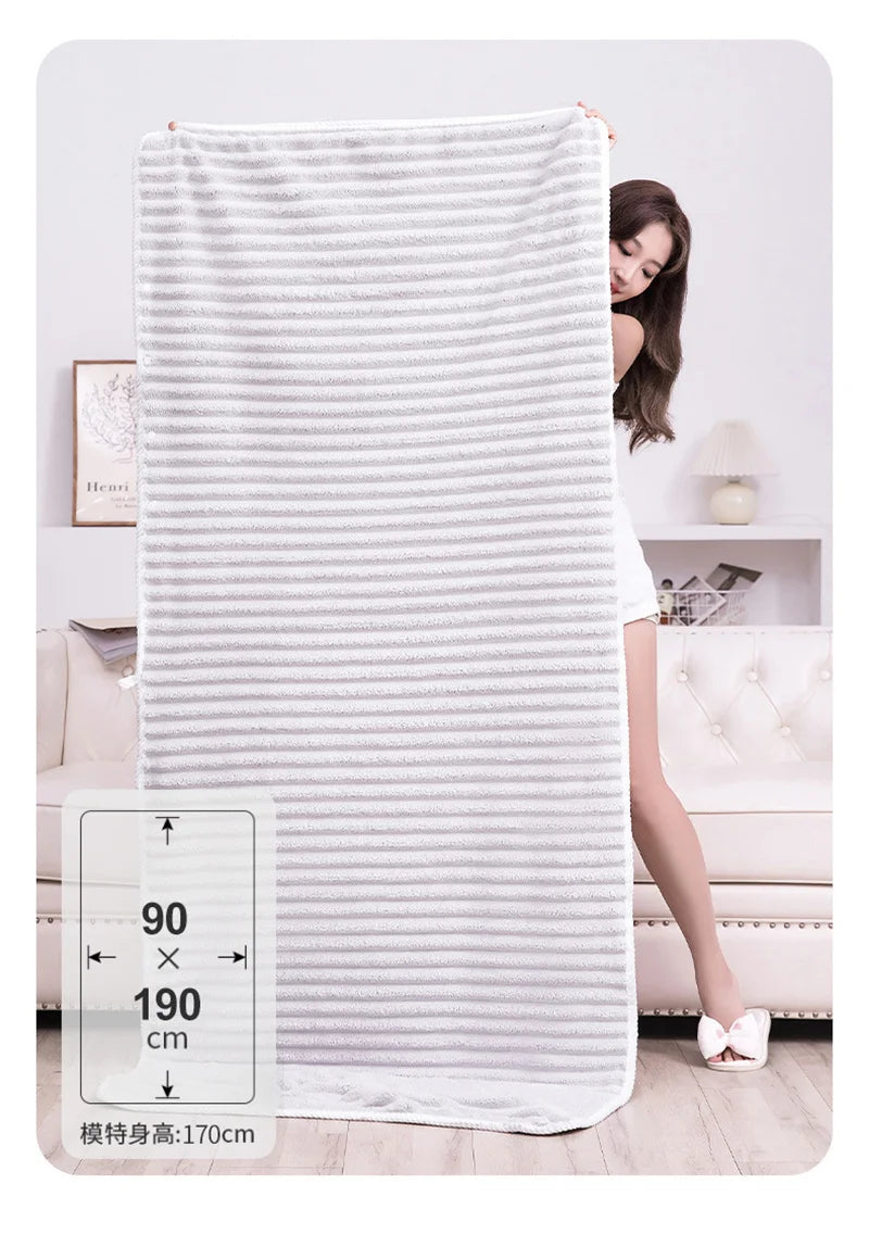 A white striped microfiber towel hanging on a rack next to a woman in a light top.