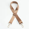 A beige nylon bag strap with a gold buckle shown in an 'X' shape.