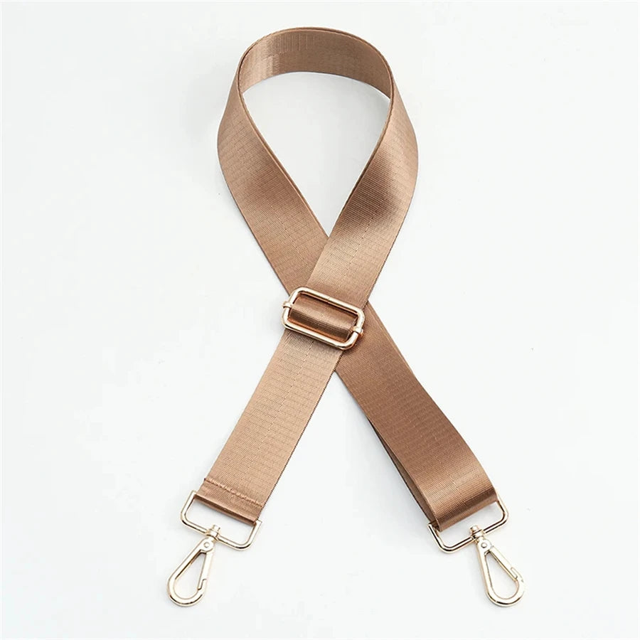 A beige nylon bag strap with a gold buckle shown in an 'X' shape.