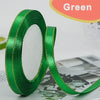 Green satin ribbon roll with gold edge, shown against a white background.