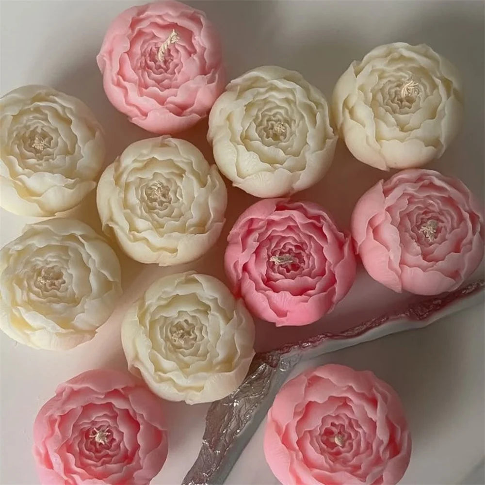 A collection of pink and white 3D peony flower silicone molds for crafting candles, resin, and soap.