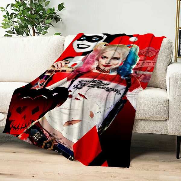 Rotes und schwarzes grafisches Überwurf mit stilisiertem Gesicht und rosa Haaren auf weißer Couch.