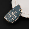 A teal car key fob cover with various buttons rests on a white plate.