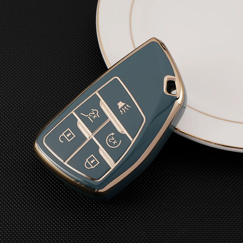 A teal car key fob cover with various buttons rests on a white plate.