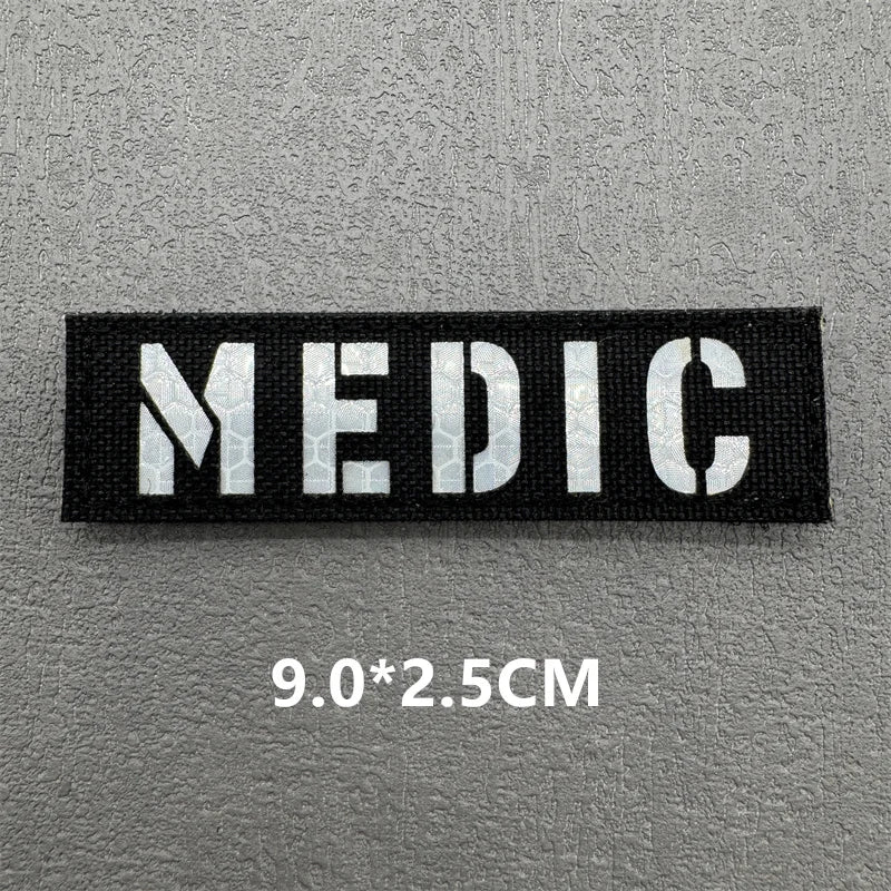 Black fabric patch with white text MEDIC and dimensions 9.0x2.5cm