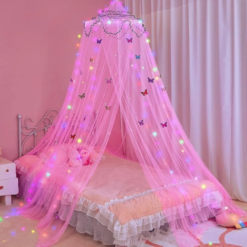 Pink sheer mosquito net dome with LED lights draped over a bed for a dreamy ambiance