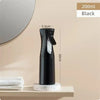 A black continuous fine mist spray bottle is displayed on a shelf next to a mirror.