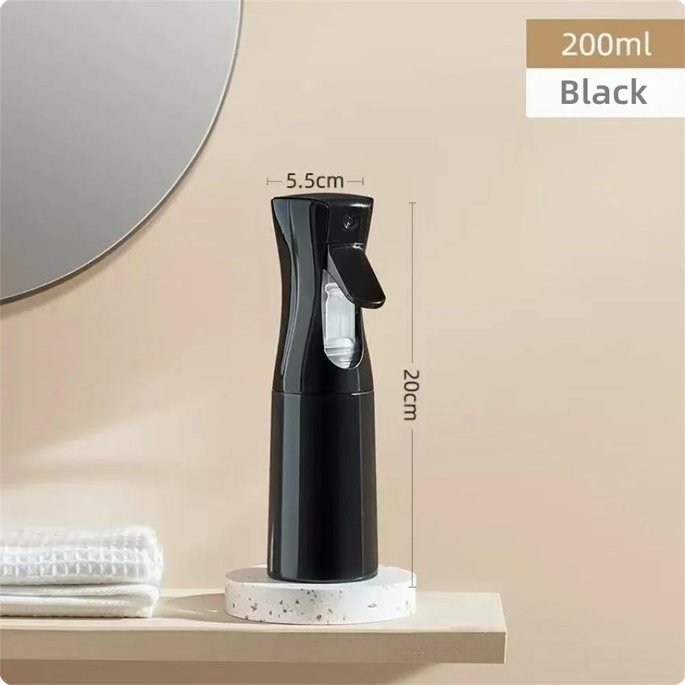 A black continuous fine mist spray bottle is displayed on a shelf next to a mirror.