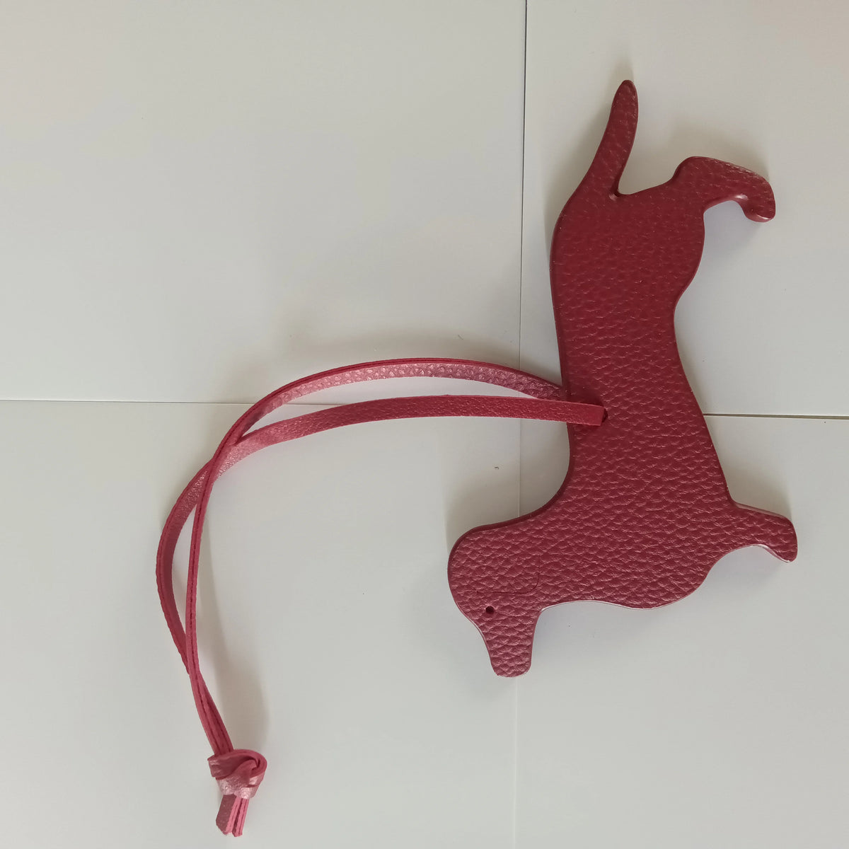A pink PU leather dachshund and bulldog shaped keychain against a white background.