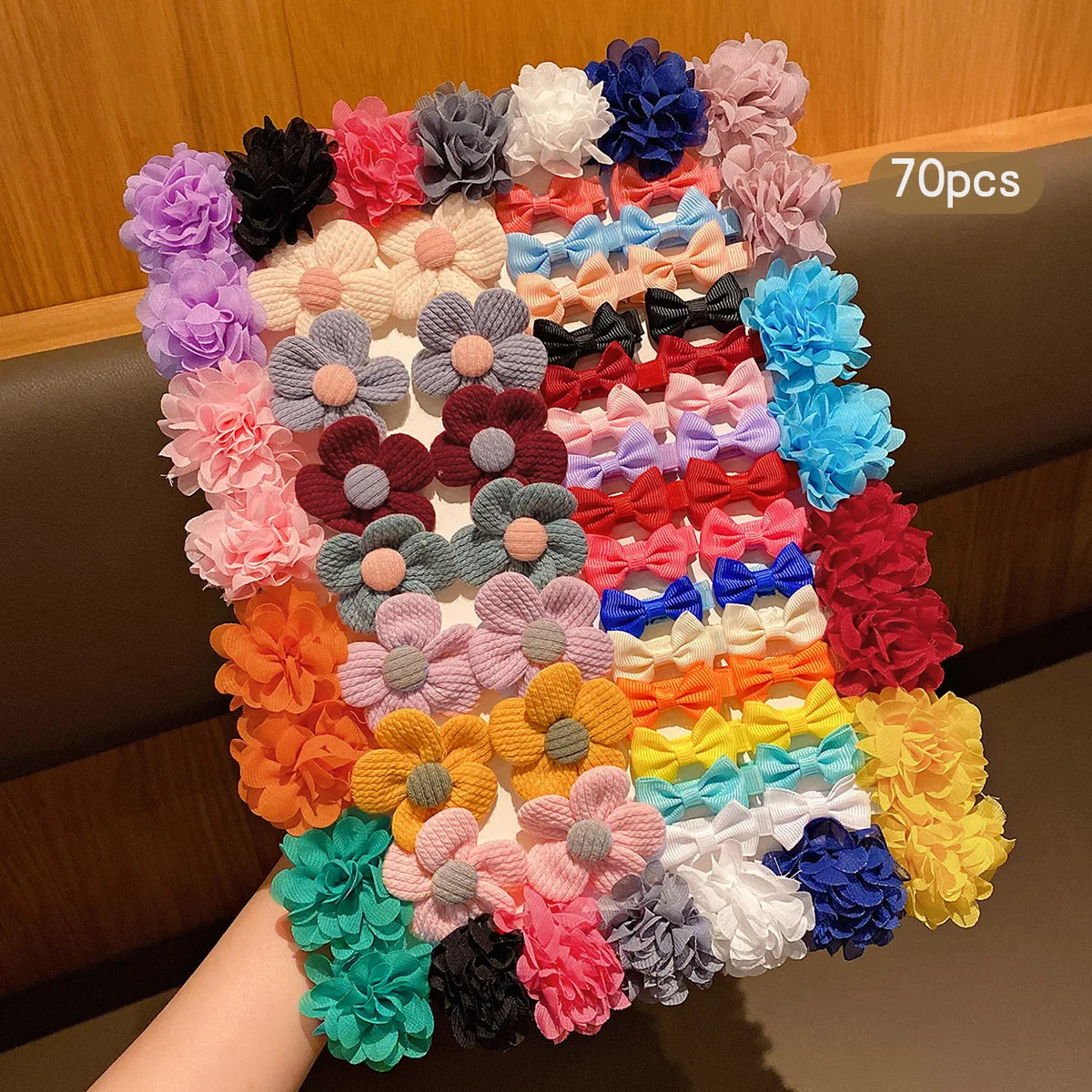A collection of 70 colorful fabric bow hair clips in various shades of pink, purple, blue, and orange.