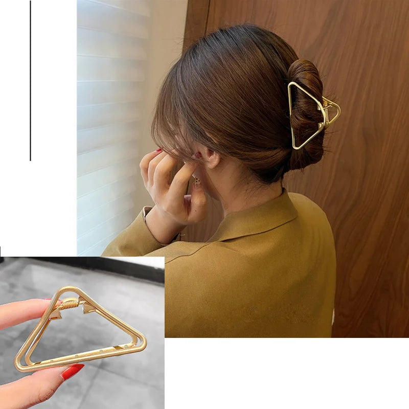 Nahaufnahme einer goldenen geometrischen Kreuz-Haarspange, die einen Haarabschnitt für eine Hochsteckfrisur sichert.