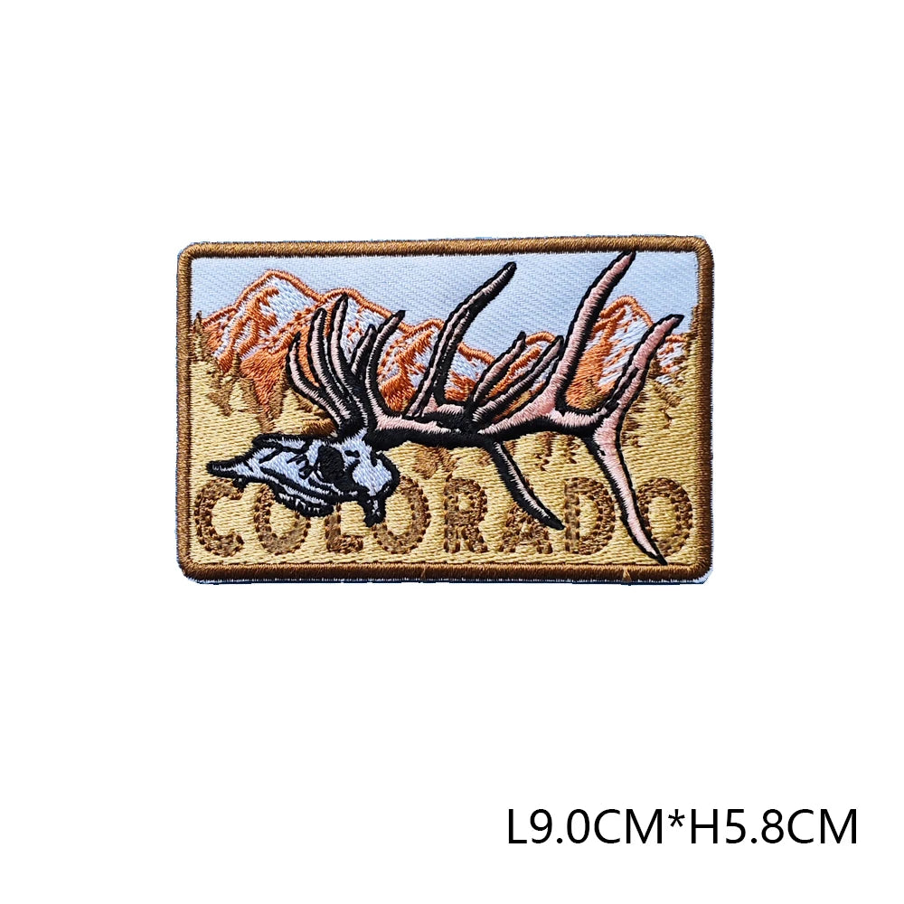 A tan embroidered patch featuring a silhouette of a deer head and mountain peaks, with the word COLORADO below it.