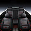 Interior view of a car with black leather seat covers featuring red stitching and accents.