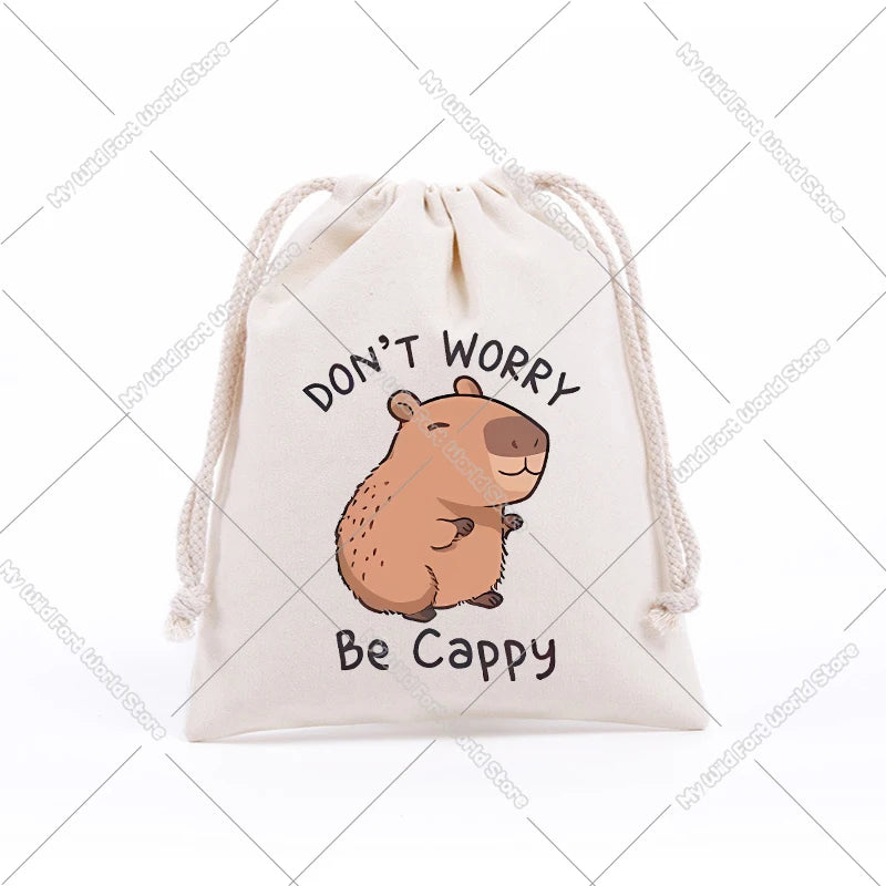 A beige drawstring storage bag featuring a cute cartoon capybara illustration with the text Don't Worry Be Cappy