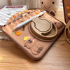 A silicone case featuring a cute cartoon capybara design for an iPad, shown on a wooden surface.