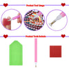 A set of DIY diamond art coasters with wooden bases and pink tools including a tool and red coaster.