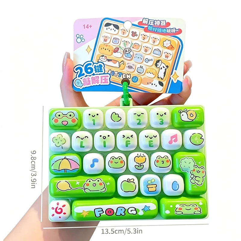 A green cartoon keycap fidget keychain with various animal and musical face designs is shown being held by a hand.
