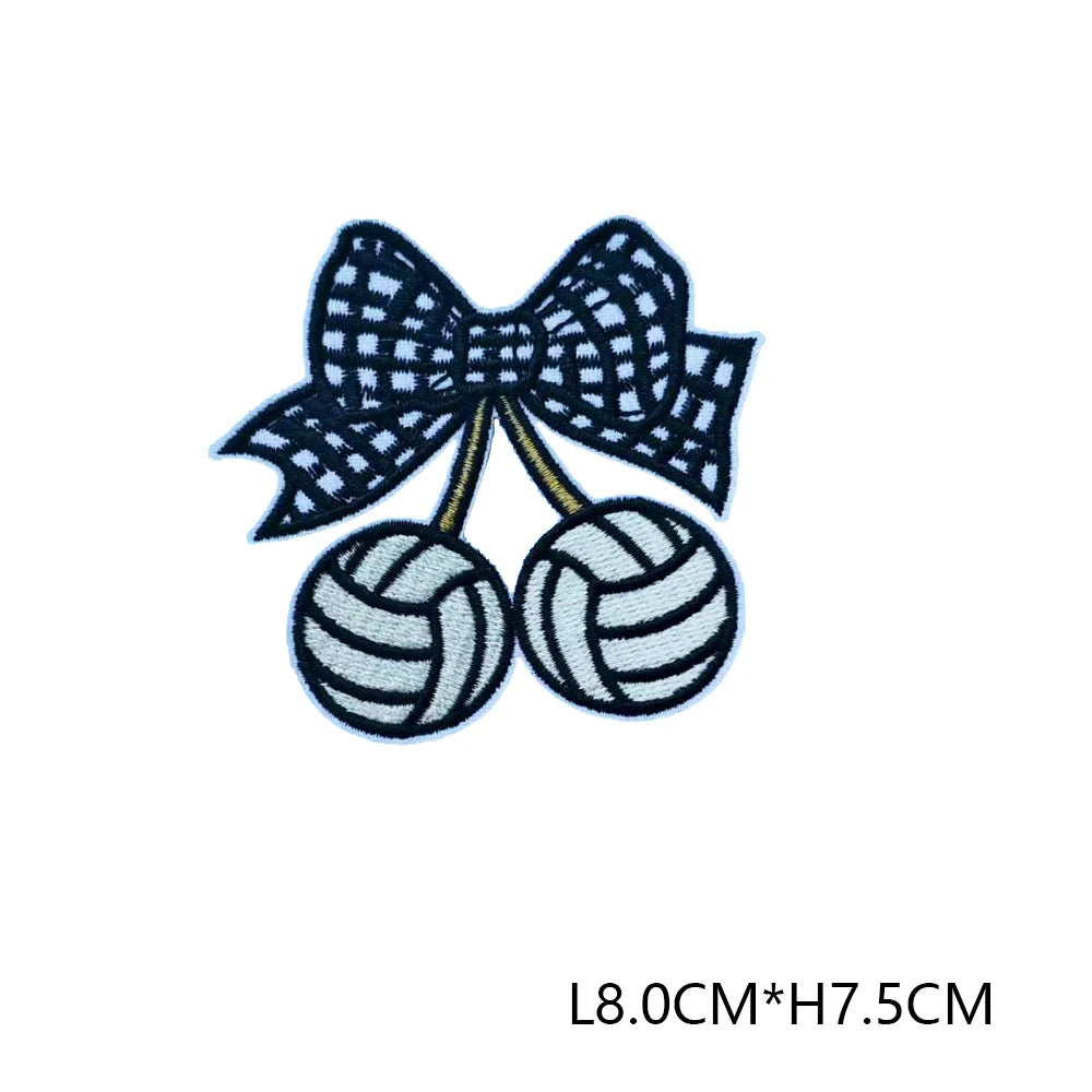 Navy blue embroidered letter patches shaped like a bow and two tennis balls