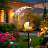 A golden crescent moon garden light featuring a silhouette of an owl and butterfly on a stake.
