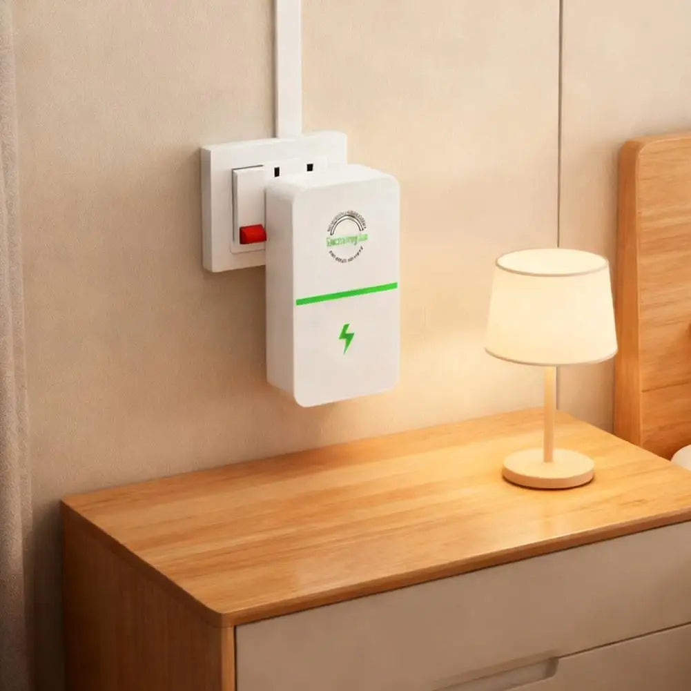 A white voltage stabilizer and energy saver plug mounted on a wall above a wooden cabinet with a lamp.
