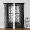 Rideaux en dentelle florale noirs avec panneaux intérieurs transparents suspendus à une fenêtre.