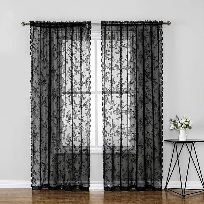 Rideaux en dentelle florale noirs avec panneaux intérieurs transparents suspendus à une fenêtre.