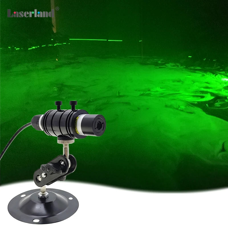 A black laser module is mounted on a base, emitting a bright green laser beam in a dark environment.