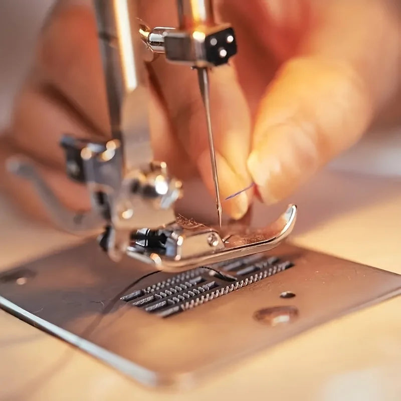 A hand is using a pair of tweezers to place or adjust needles on an anti-skip sewing machine.