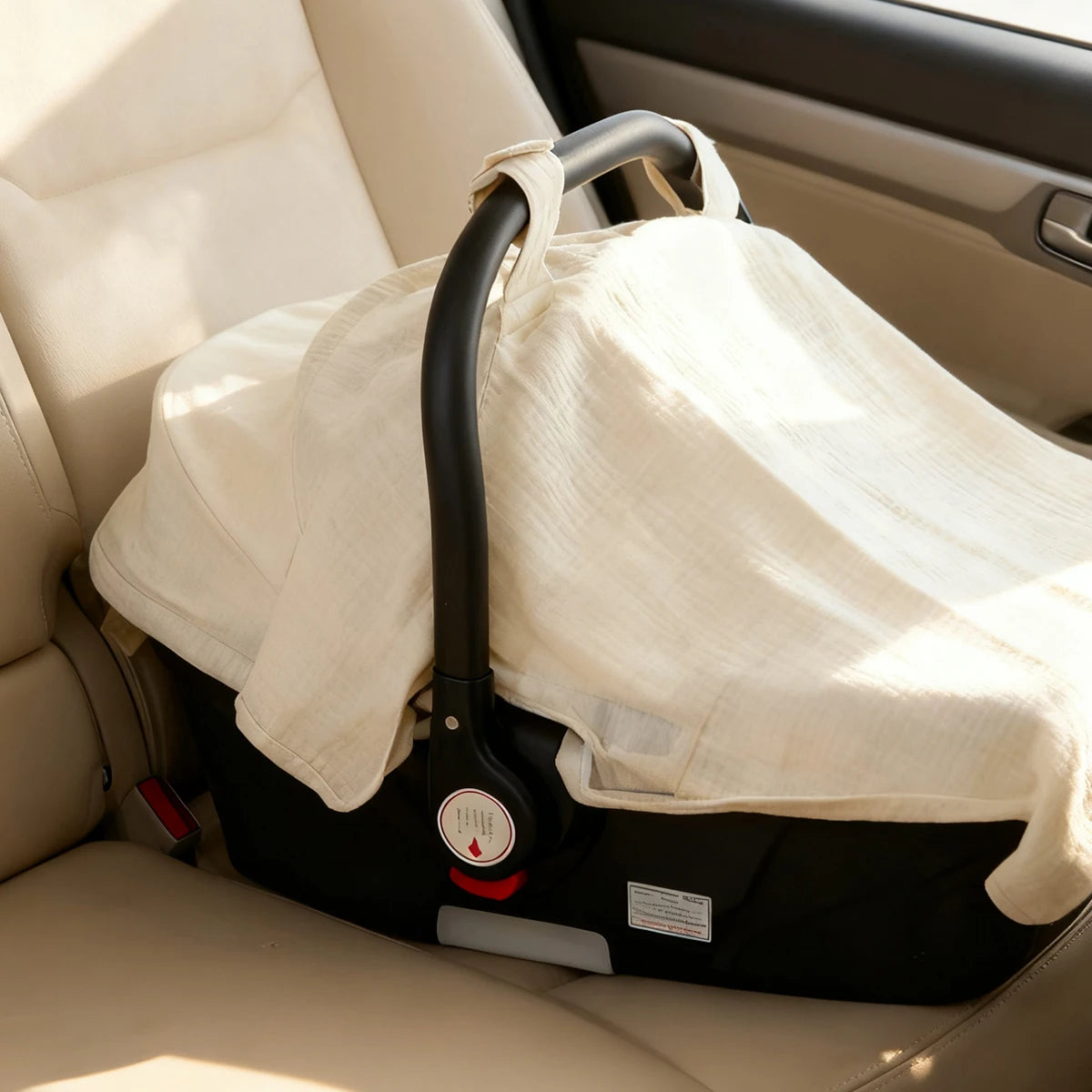 A beige breathable muslin cotton baby car seat cover is shown placed in the interior of a car seat.
