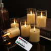 A set of glowing yellow LED tea light candles in glass holders with a remote control visible on a dark surface.