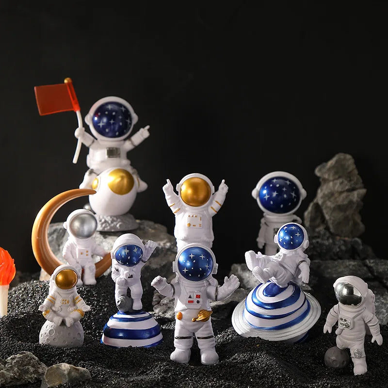 A collection of handcrafted astronaut figurine resin spacemen desk decor against a dark background.