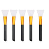 Five silicone facial mask brushes with white heads and gold bases and black handles