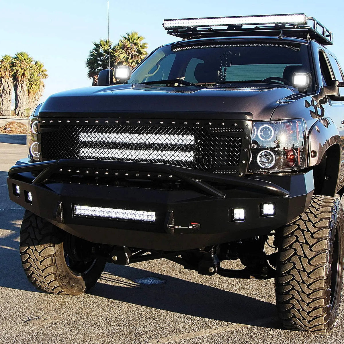 A black truck equipped with 18W LED flood light pods on the grille and bumper.