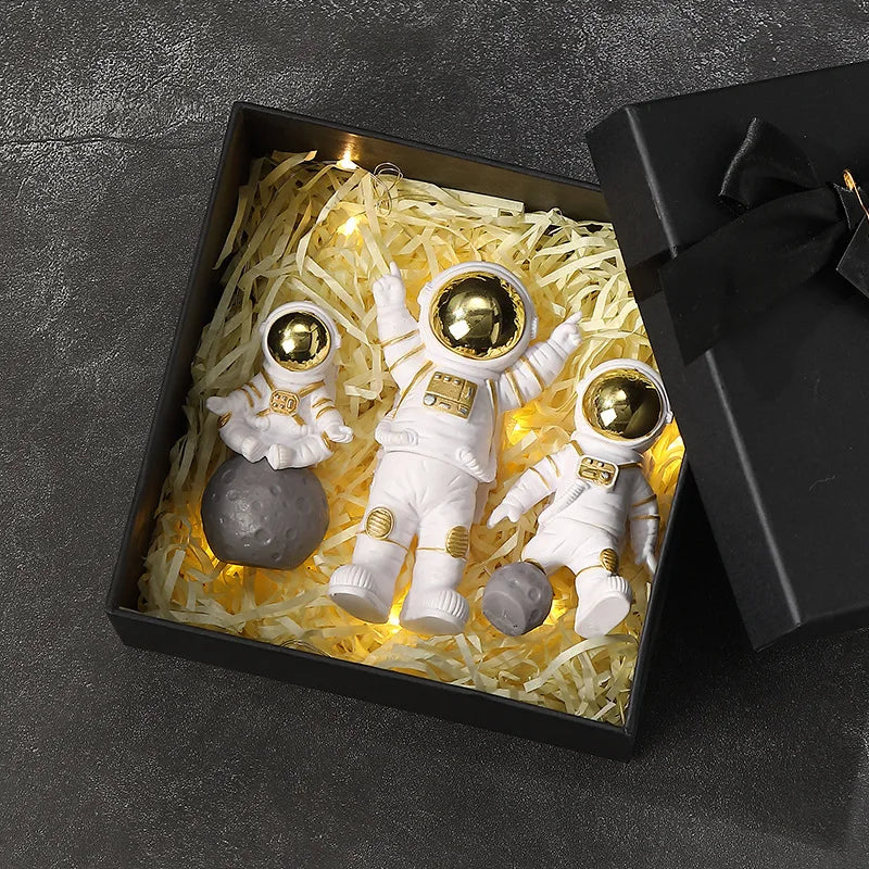 Handcrafted astronaut figurine resin spaceman desk decor displayed in a black box with gold lighting.