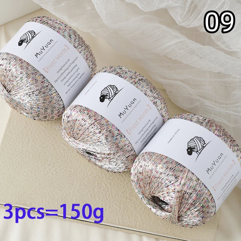 Three balls of glitter yarn are displayed on a light surface with a number 09 in the corner.