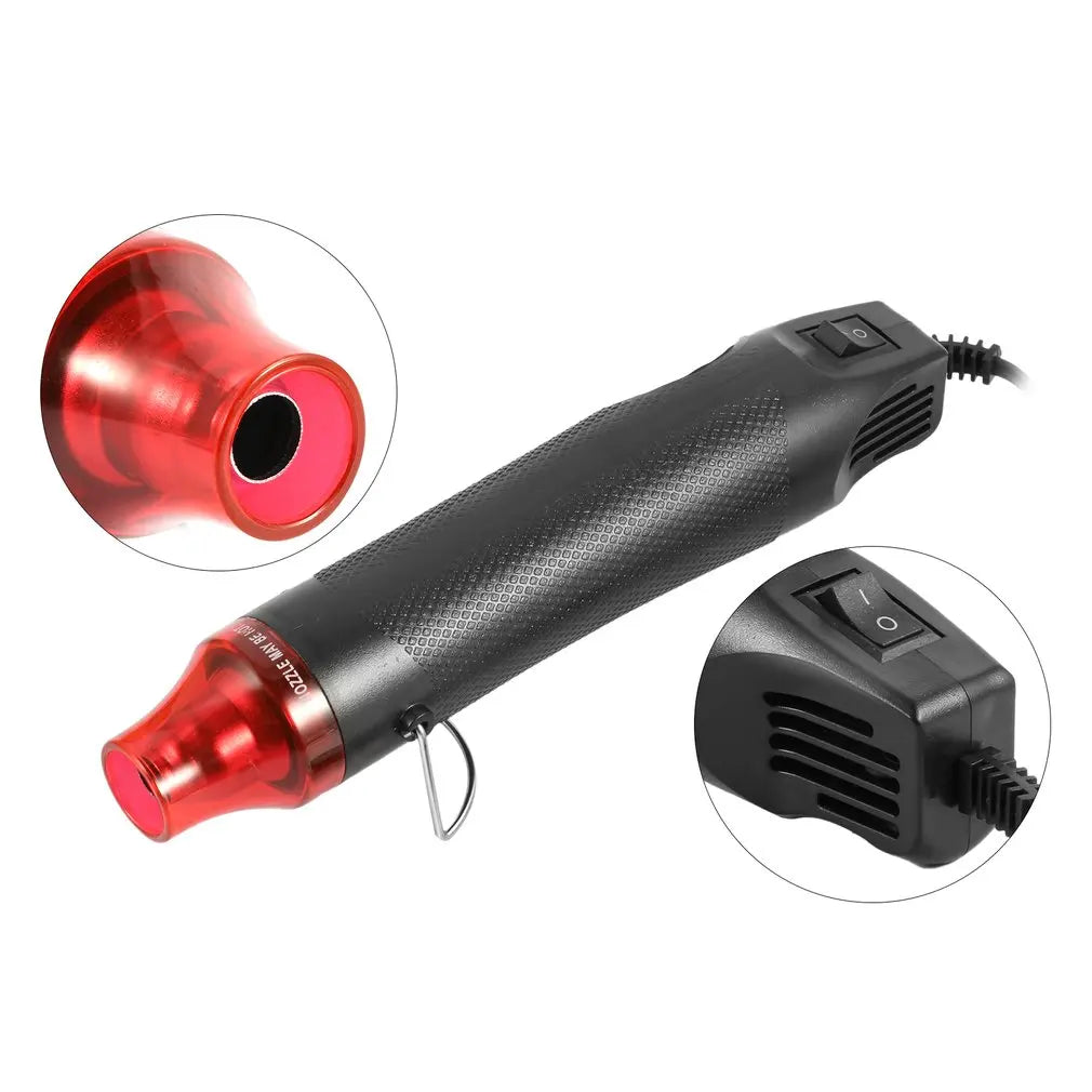 A black electric heat gun with a red nozzle and a separate hot/cold air mode attachment.