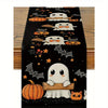 Black Halloween table runner featuring white ghosts, pumpkins, bats, and jack-o'-lanterns