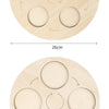 A round wooden learning board with six circular cutouts for a life cycle model, showing arrows indicating a process.
