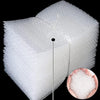 A stack of clear bubble mailers showing cushioned protection, with a small piece of white bubble wrap visible.