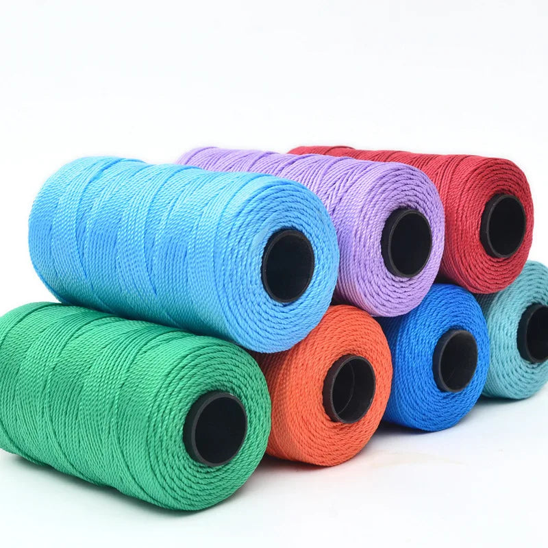 A collection of colorful 3-ply polyester knitting yarn spools in shades of blue, purple, red, and green.